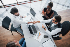young employees sitting in the office at the table and using a laptop, a team work brainstorming meeting concept.